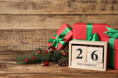 Block calendar with Boxing Day date near gifts on wooden table. Space for text Photo of Block calendar with Boxing Day date near gifts on wooden table. Space for text