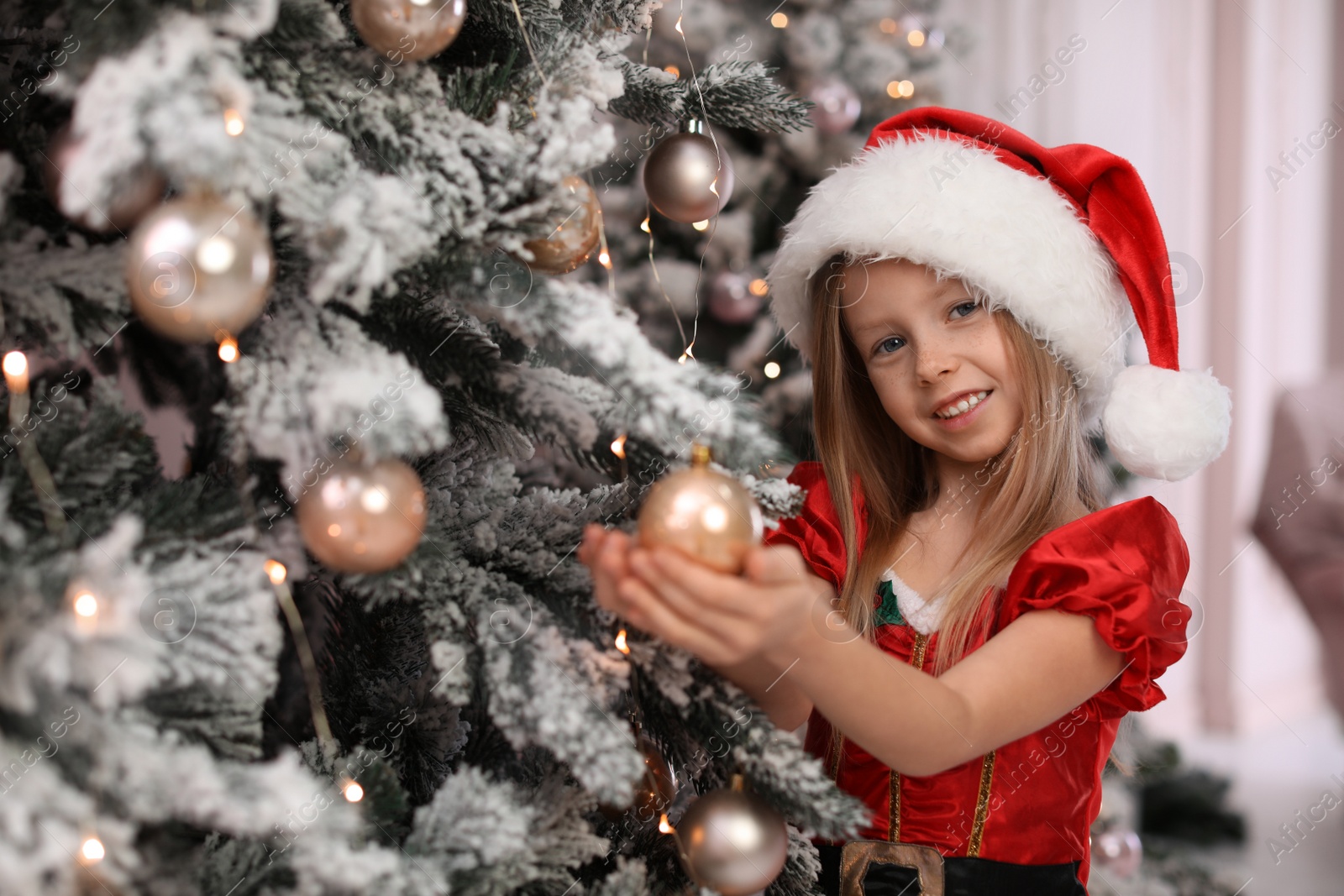 Cute little child near Christmas tree at home Photo of Cute little child near Christmas tree at home