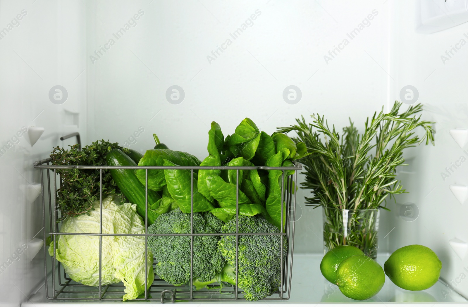 Different green vegetables and fruit in refrigerator Photo of Different green vegetables and fruit in refrigerator