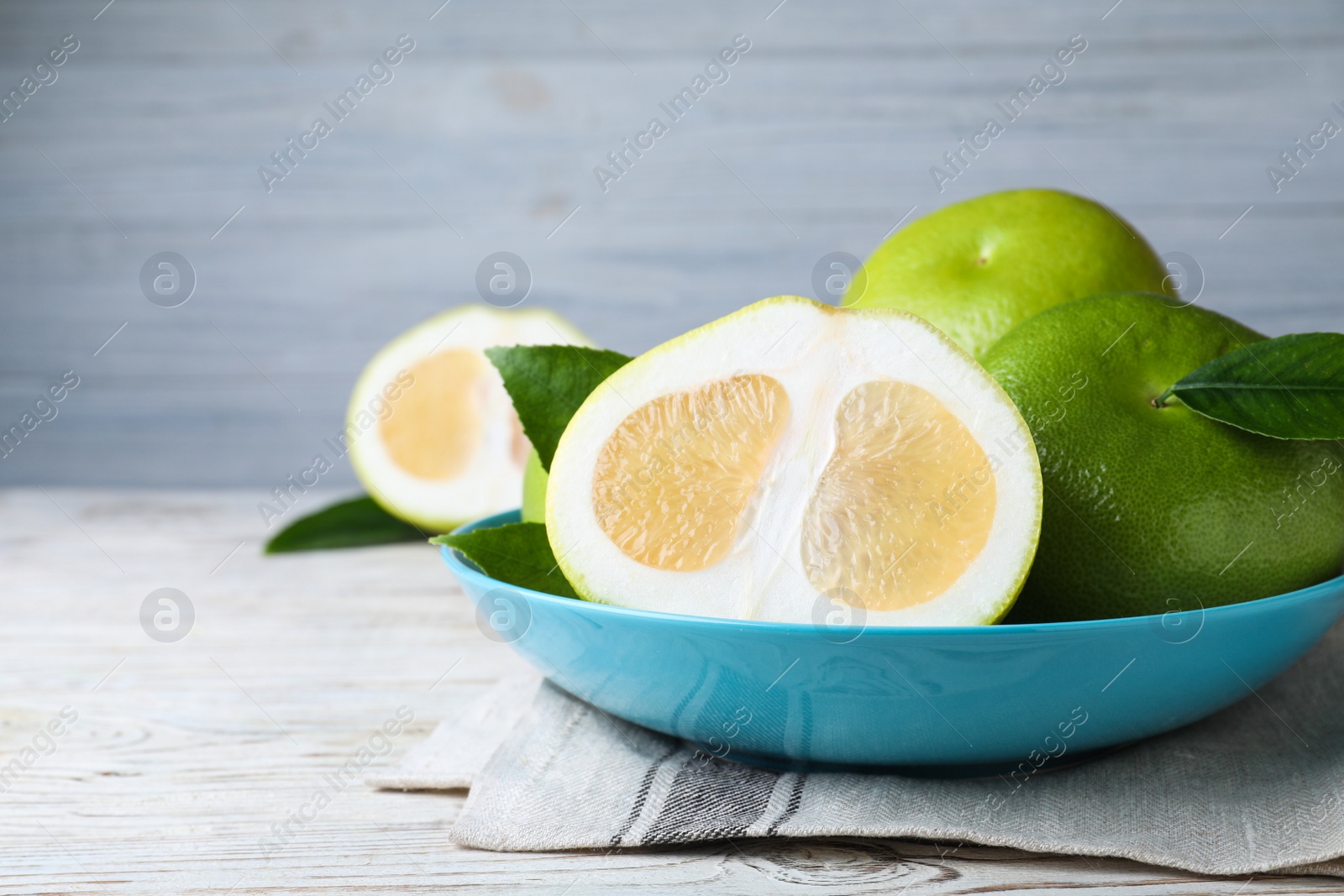 Whole and cut sweetie fruits on white wooden table Photo of Whole and cut sweetie fruits on white wooden table