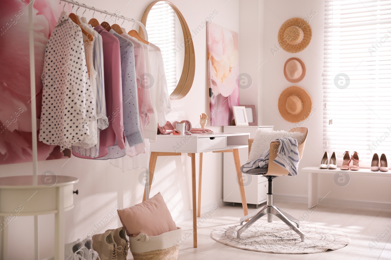 Dressing room interior with stylish makeup table, clothes and accessories Photo of Dressing room interior with stylish makeup table, clothes and accessories