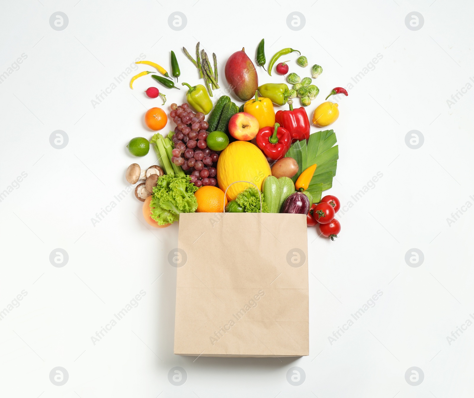 Paper bag with assortment of fresh organic fruits and vegetables on white background, top view Photo of Paper bag with assortment of fresh organic fruits and vegetables on white background, top view