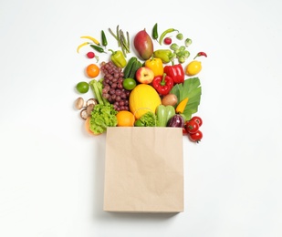 Paper bag with assortment of fresh organic fruits and vegetables on white background, top view Photo of Paper bag with assortment of fresh organic fruits and vegetables on white background, top view