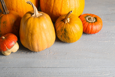 Many different ripe pumpkins on wooden table Photo of Many different ripe pumpkins on wooden table