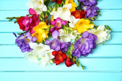 Beautiful freesia flowers on wooden background Photo of Beautiful freesia flowers on wooden background