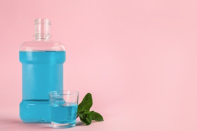 Mouthwash and fresh mint on pink background, space for text Photo of Mouthwash and fresh mint on pink background, space for text