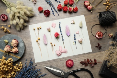 Flat lay composition with beautiful dry flowers on wooden background Photo of Flat lay composition with beautiful dry flowers on wooden background