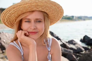 Beautiful young woman with straw hat near sea on sunny day in summer Photo of Beautiful young woman with straw hat near sea on sunny day in summer