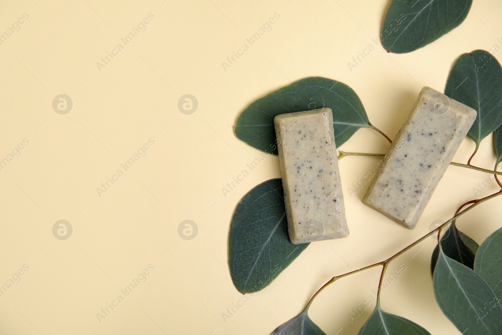 Flat lay of soap bars and green leaves on beige background, space for text. Eco friendly personal care product Photo of Flat lay of soap bars and green leaves on beige background, space for text. Eco friendly personal care product