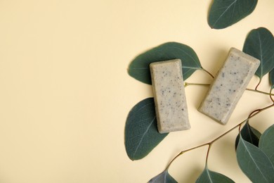 Flat lay of soap bars and green leaves on beige background, space for text. Eco friendly personal care product Photo of Flat lay of soap bars and green leaves on beige background, space for text. Eco friendly personal care product