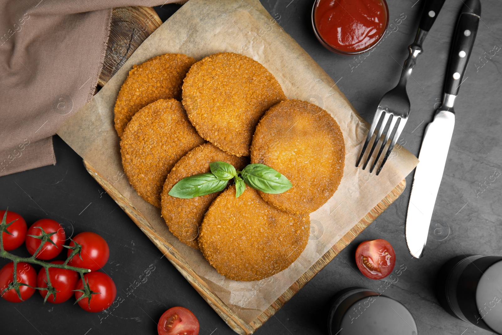 Delicious fried breaded cutlets served on black table, flat lay Photo of Delicious fried breaded cutlets served on black table, flat lay
