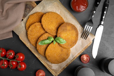 Delicious fried breaded cutlets served on black table, flat lay Photo of Delicious fried breaded cutlets served on black table, flat lay