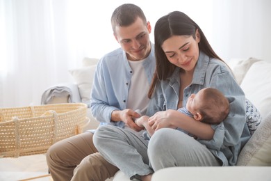 Happy family with cute baby on sofa at home Photo of Happy family with cute baby on sofa at home