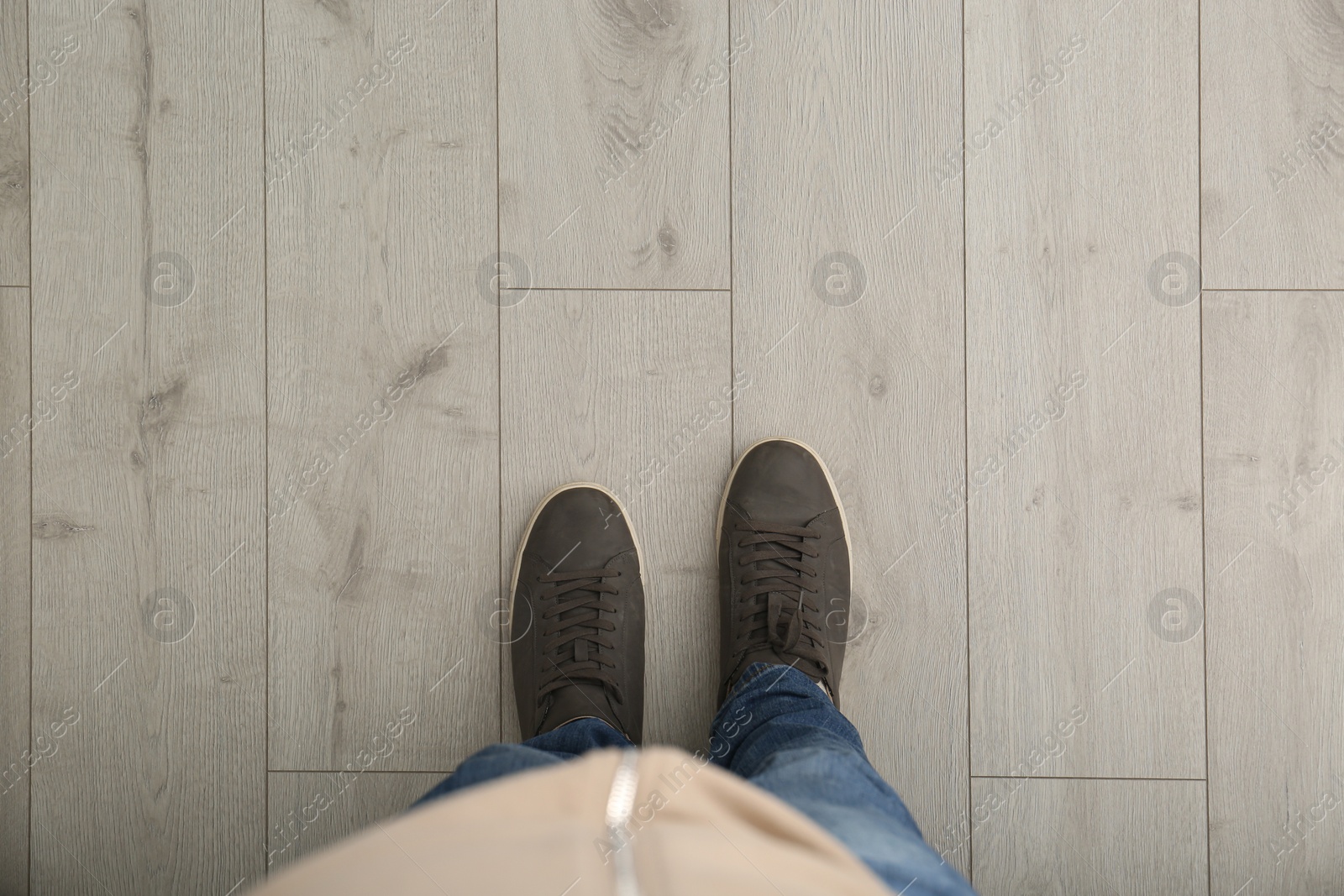 Person in brown shoes standing on wooden floor, top view. Space for text Photo of Person in brown shoes standing on wooden floor, top view. Space for text