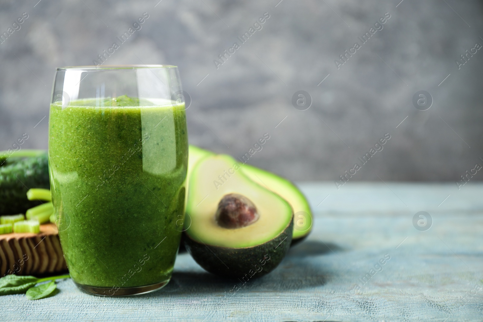 Delicious green juice and fresh ingredients on light blue wooden table, space for text Photo of Delicious green juice and fresh ingredients on light blue wooden table, space for text