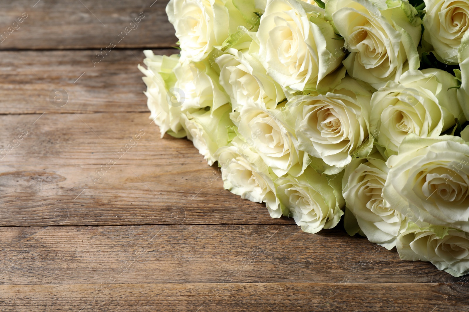 Luxury bouquet of fresh roses on wooden table, closeup. Space for text Photo of Luxury bouquet of fresh roses on wooden table, closeup. Space for text