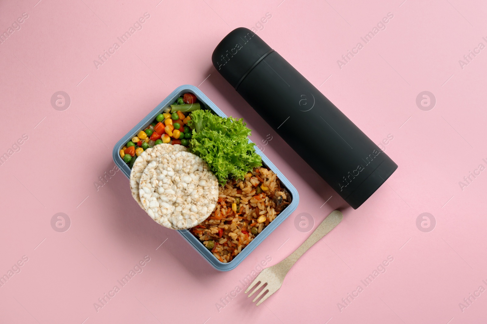 Thermos and lunch box with food on pink background, flat lay Photo of Thermos and lunch box with food on pink background, flat lay