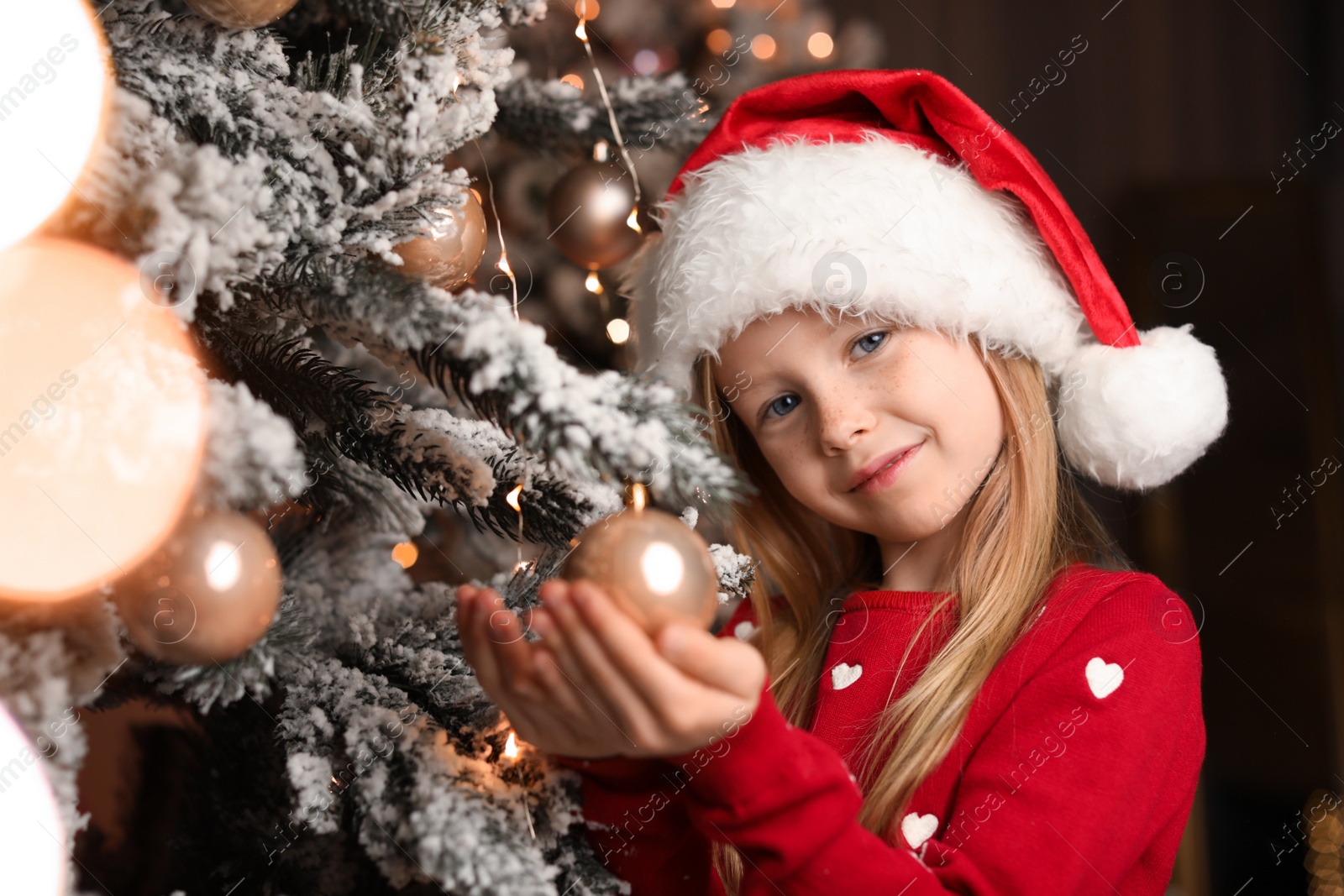Cute little child near Christmas tree at home Photo of Cute little child near Christmas tree at home