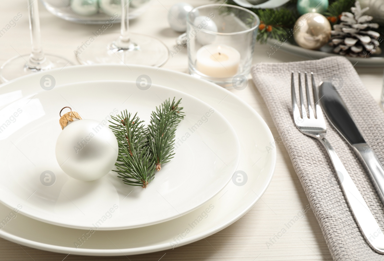 Festive table setting with beautiful dishware and Christmas decor on white wooden background Photo of Festive table setting with beautiful dishware and Christmas decor on white wooden background