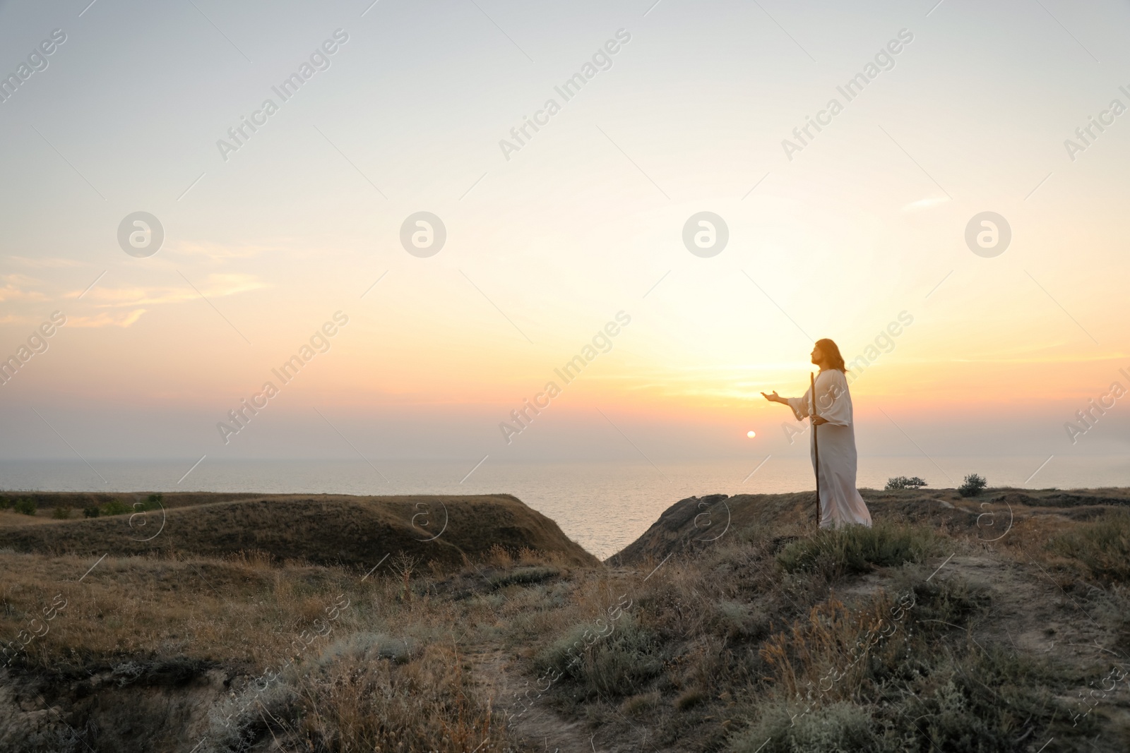 Jesus Christ on hills at sunset. Space for text Photo of Jesus Christ on hills at sunset. Space for text