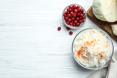 Flat lay composition with fermented cabbage on white wooden table, space for text Photo of Flat lay composition with fermented cabbage on white wooden table, space for text