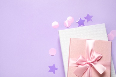 Beautiful gift boxes and confetti on violet background, flat lay. Space for text Photo of Beautiful gift boxes and confetti on violet background, flat lay. Space for text