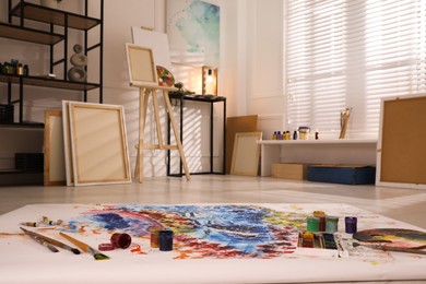 Wooden easel and abstract picture in art studio Photo of Wooden easel and abstract picture in art studio