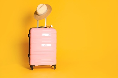 Travel suitcase with hat and sunglasses on yellow background, space for text. Summer vacation Photo of Travel suitcase with hat and sunglasses on yellow background, space for text. Summer vacation