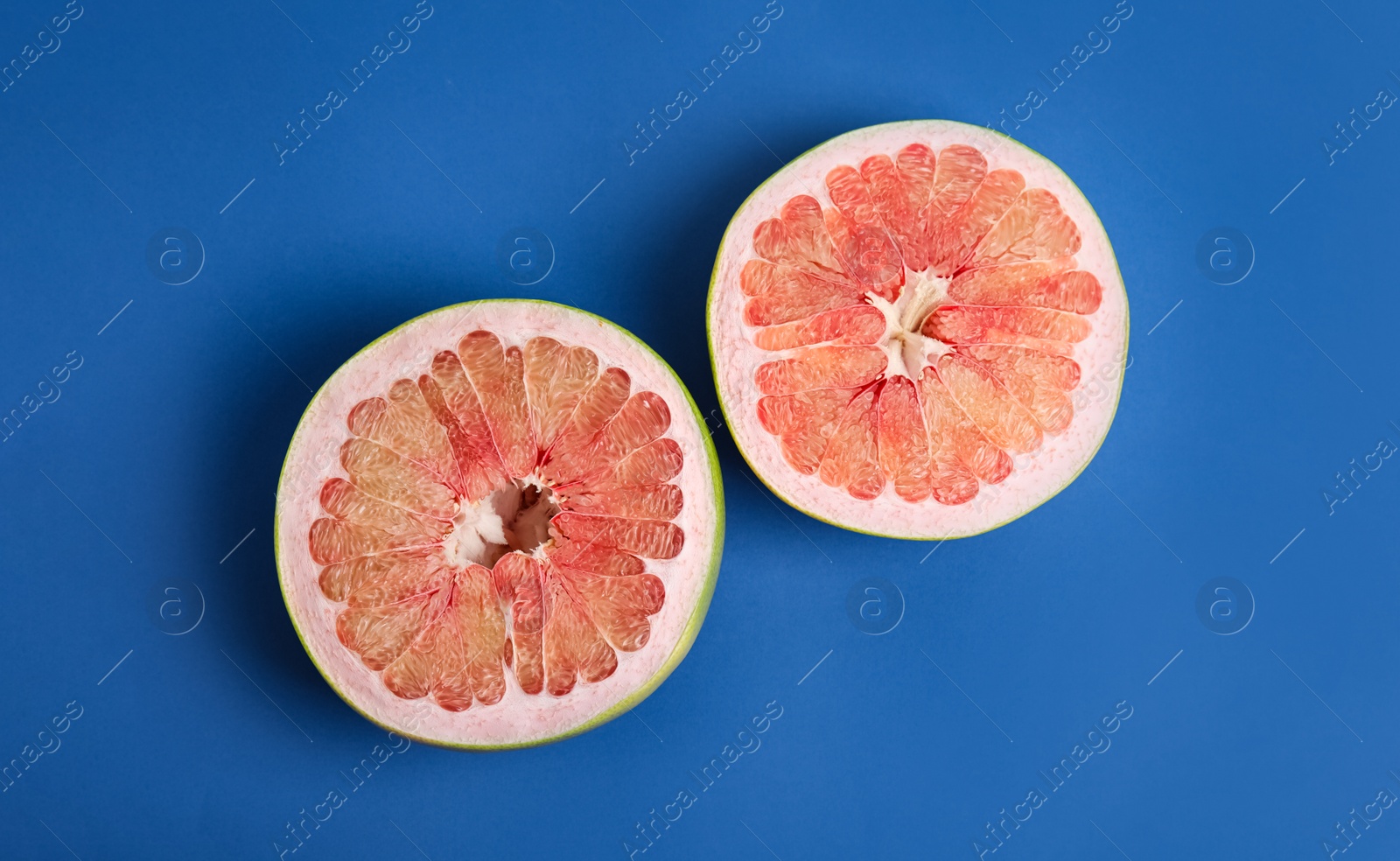 Fresh cut pomelo fruit on blue background, flat lay Photo of Fresh cut pomelo fruit on blue background, flat lay