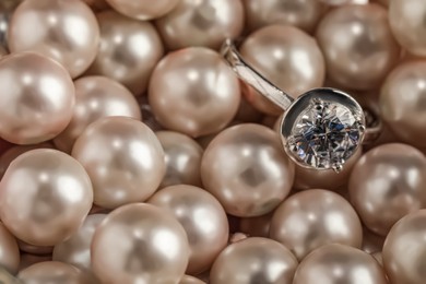 Beautiful decor pearls and engagement ring, closeup. Space for text Photo of Beautiful decor pearls and engagement ring, closeup. Space for text