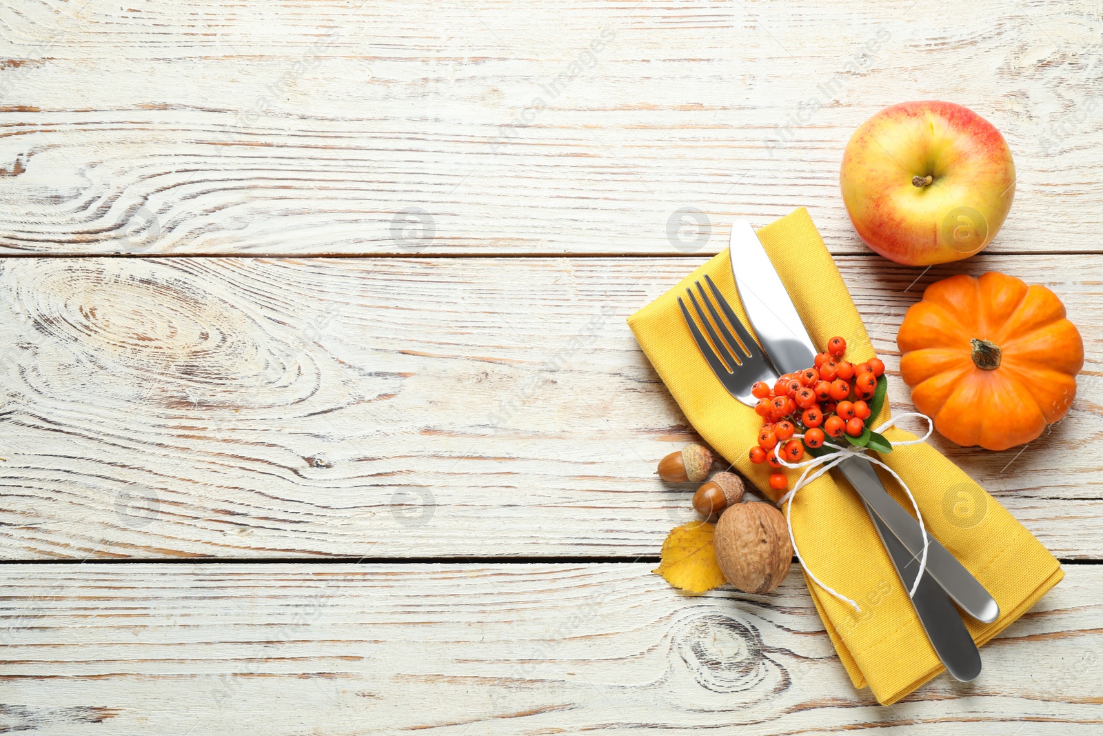 Top view of cutlery with napkin and autumn items on white wooden table, space for text. Thanksgiving Day Photo of Top view of cutlery with napkin and autumn items on white wooden table, space for text. Thanksgiving Day