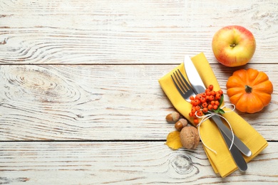 Top view of cutlery with napkin and autumn items on white wooden table, space for text. Thanksgiving Day Photo of Top view of cutlery with napkin and autumn items on white wooden table, space for text. Thanksgiving Day
