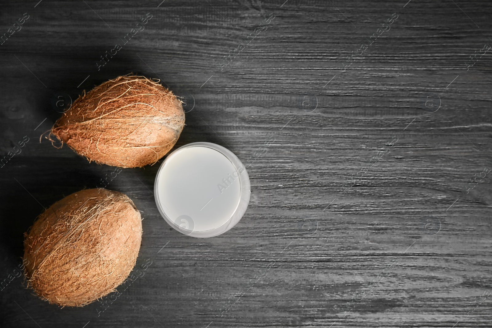 Glass of coconut water and fresh nuts on wooden background, top view Photo of Glass of coconut water and fresh nuts on wooden background, top view