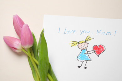 Drawing for Mother's day and beautiful tulips on beige background, flat lay Photo of Drawing for Mother's day and beautiful tulips on beige background, flat lay