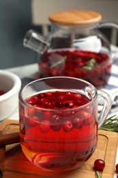 Tasty hot cranberry tea and fresh ingredients on table Photo of Tasty hot cranberry tea and fresh ingredients on table