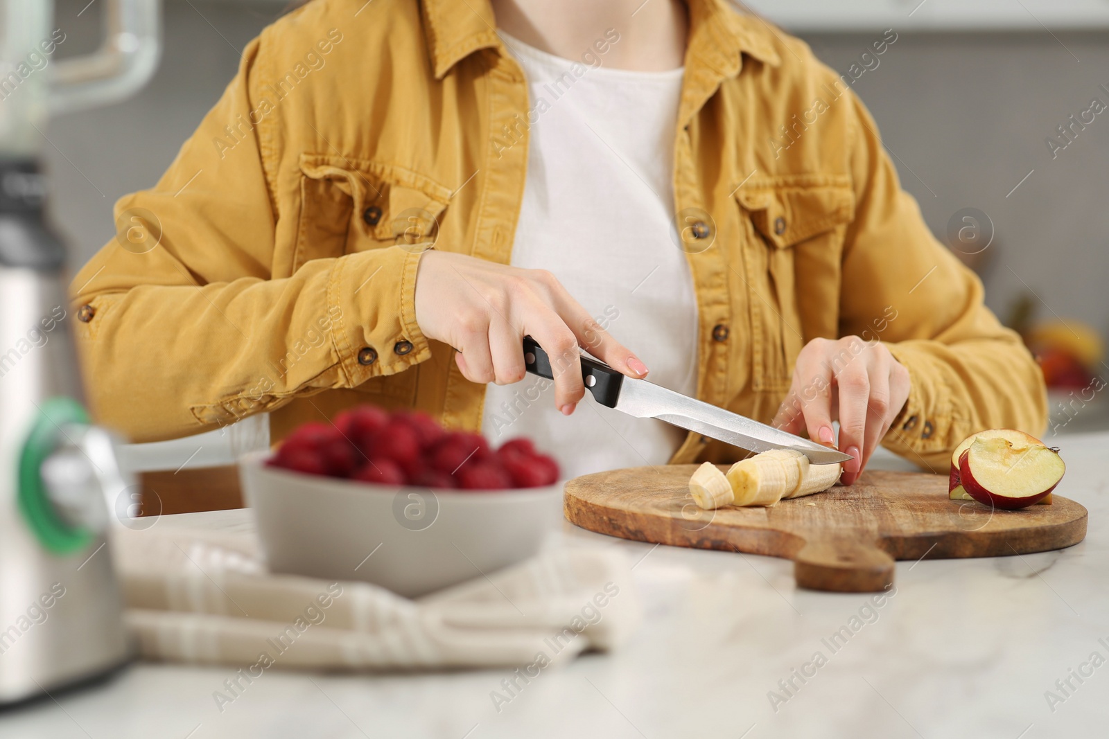 Woman preparing ingredients for tasty smoothie at white marble table in kitchen, closeup Photo of Woman preparing ingredients for tasty smoothie at white marble table in kitchen, closeup