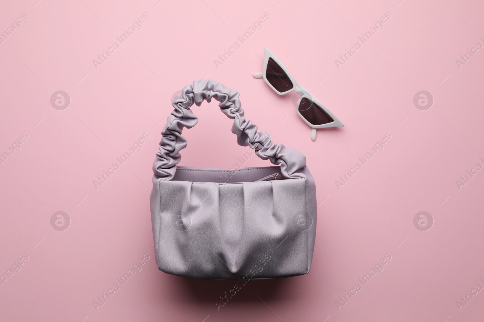 Stylish woman's bag and sunglasses on pink background, flat lay Photo of Stylish woman's bag and sunglasses on pink background, flat lay
