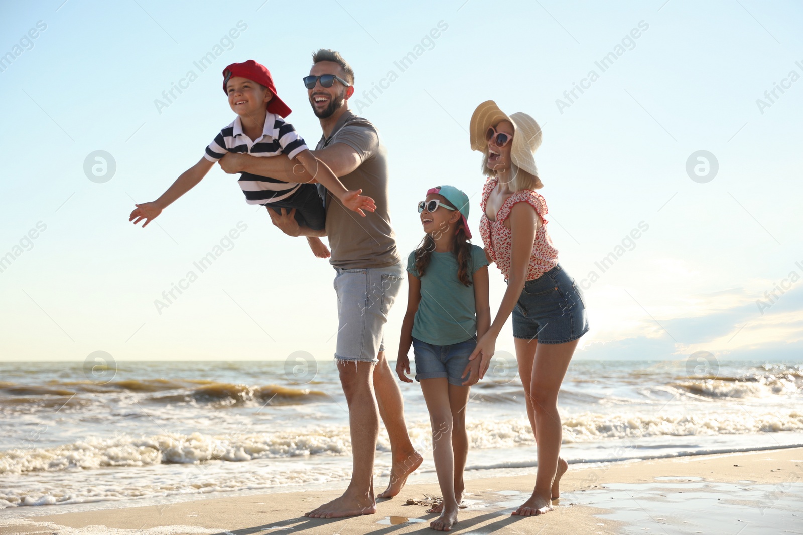 Happy family having fun on sandy beach near sea Photo of Happy family having fun on sandy beach near sea