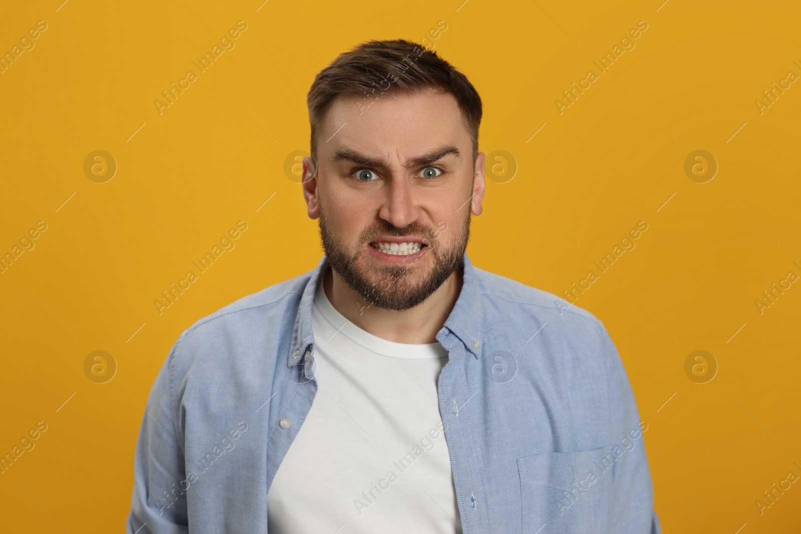 Angry young man on yellow background. Hate concept Photo of Angry young man on yellow background. Hate concept