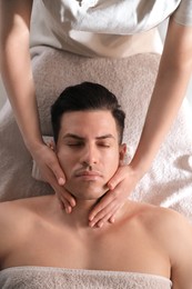 Man receiving facial massage in beauty salon, top view Photo of Man receiving facial massage in beauty salon, top view