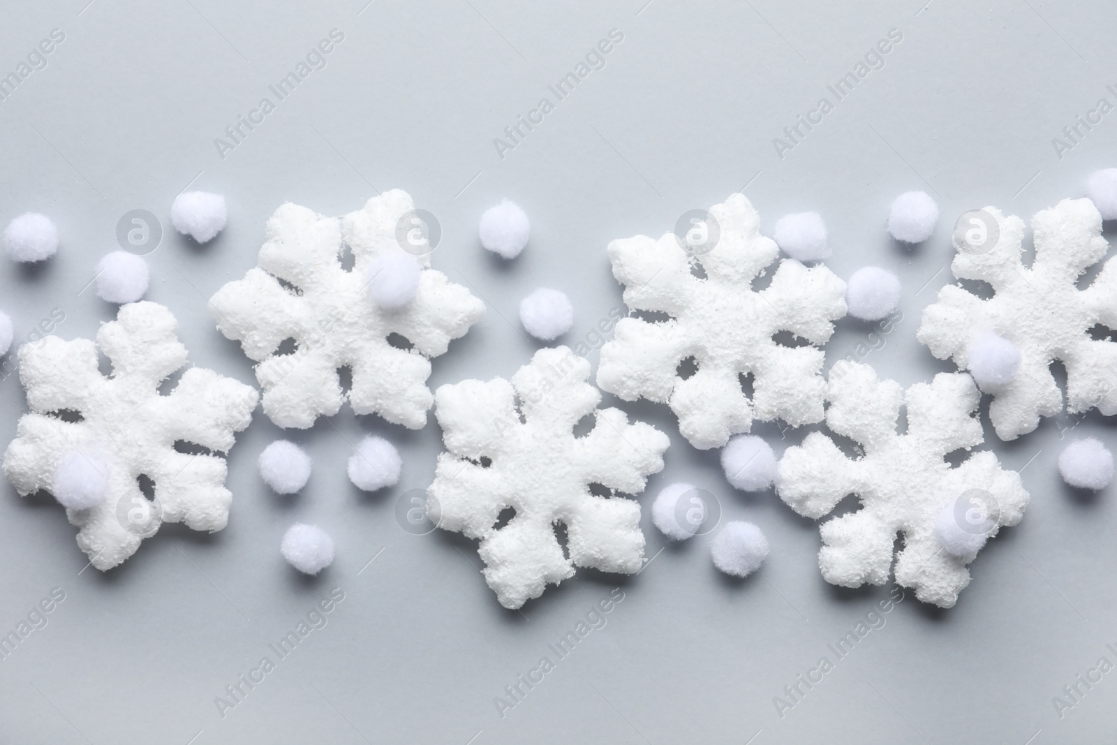 Beautiful snowflakes and decorative balls on white background, flat lay Photo of Beautiful snowflakes and decorative balls on white background, flat lay