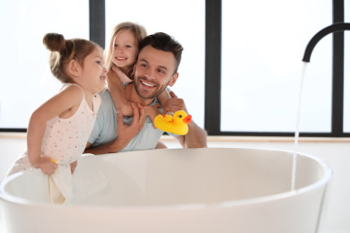 Young father with little daughters in bathroom Photo of Young father with little daughters in bathroom