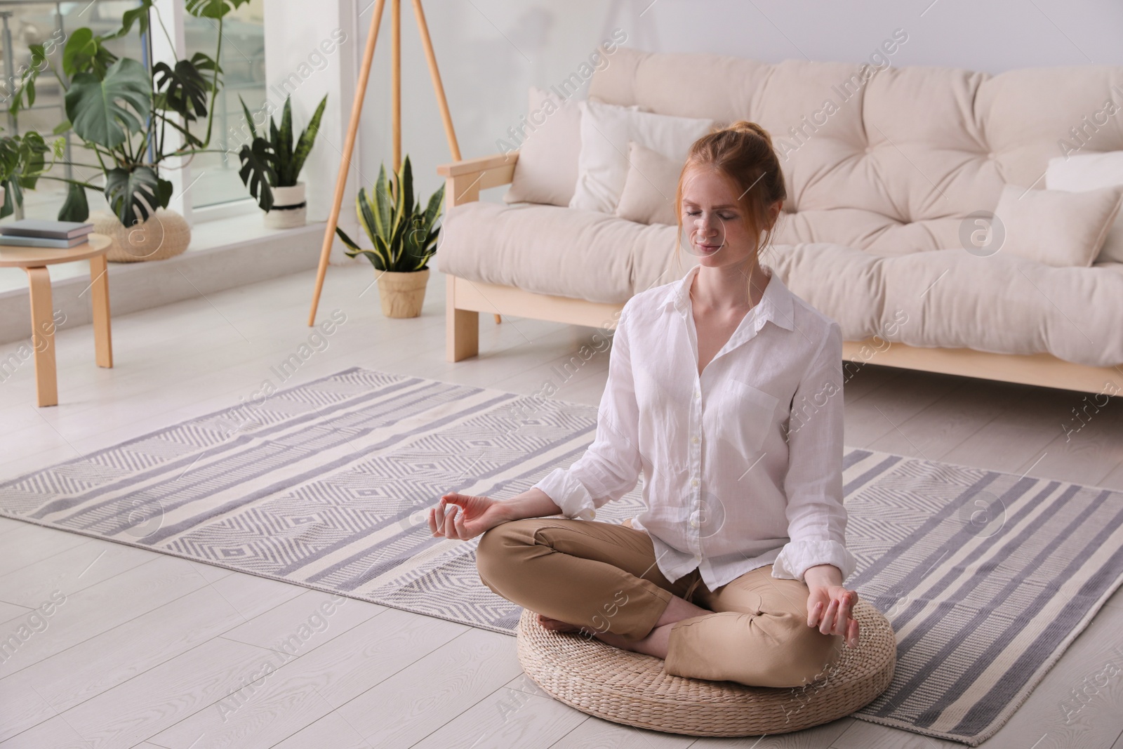 Woman meditating on wicker mat at home. Space for text Photo of Woman meditating on wicker mat at home. Space for text