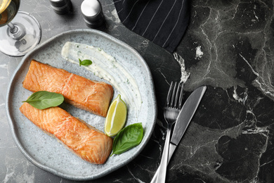 Tasty cooked red fish on dark marble table, flat lay Photo of Tasty cooked red fish on dark marble table, flat lay