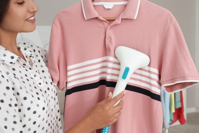 Woman steaming pink shirt at home, closeup Photo of Woman steaming pink shirt at home, closeup