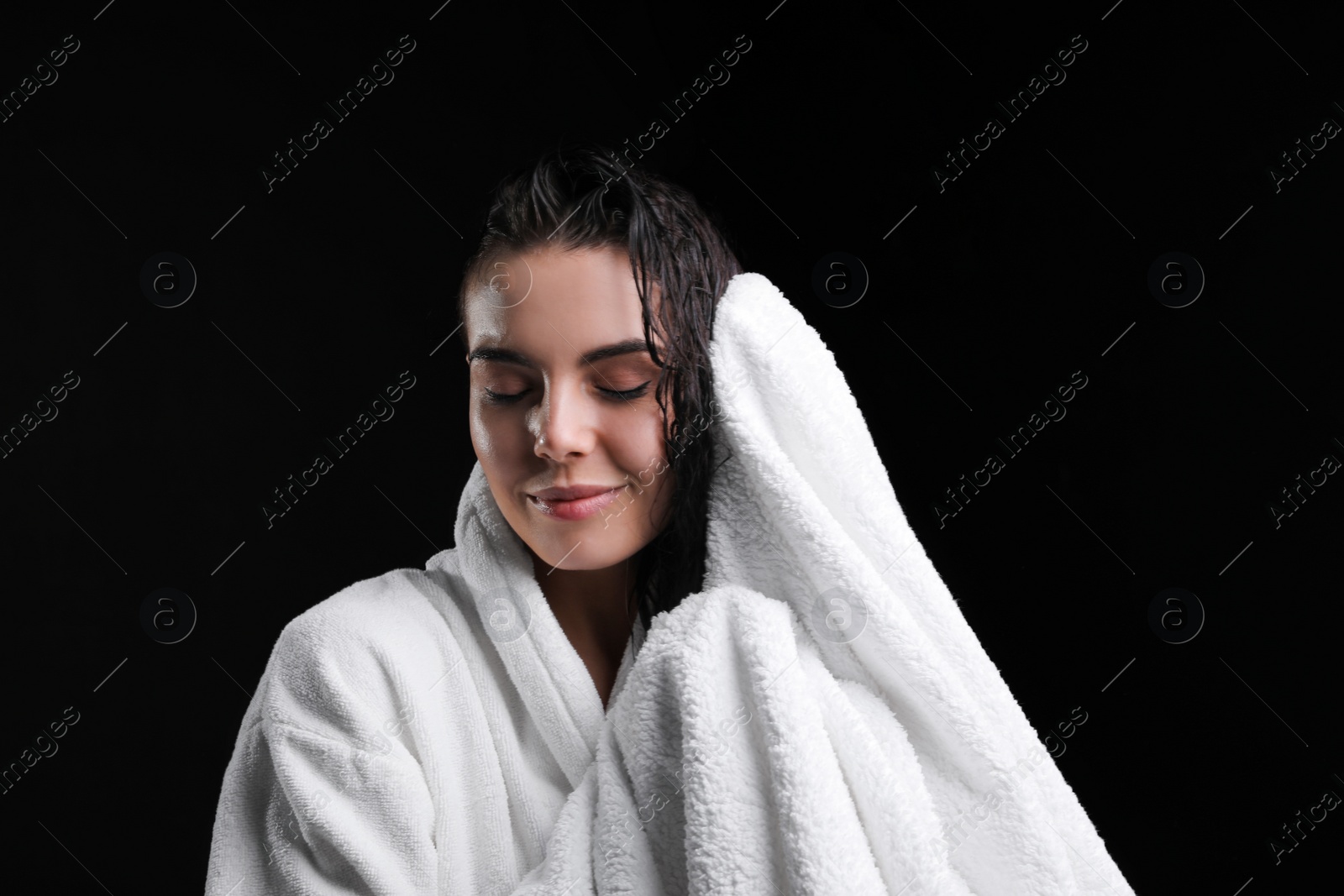 Pretty woman drying hair with towel after washing on black background Photo of Pretty woman drying hair with towel after washing on black background