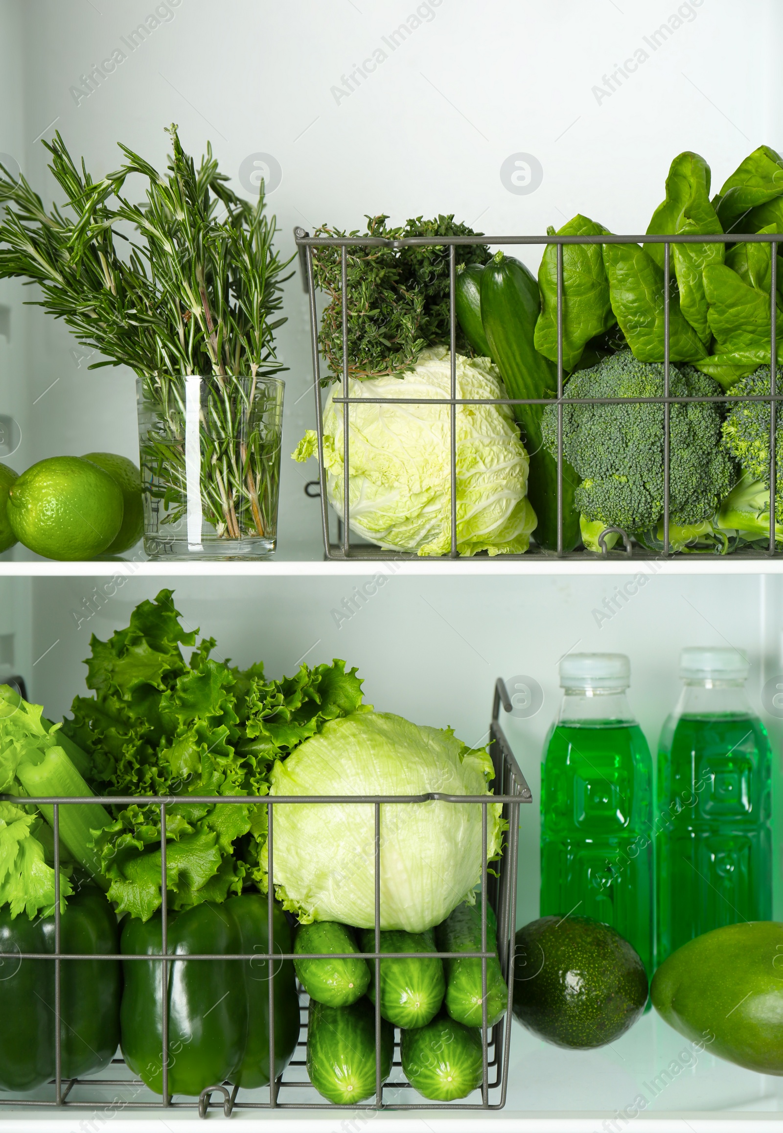 Different green vegetables and fruits on shelves of refrigerator Photo of Different green vegetables and fruits on shelves of refrigerator
