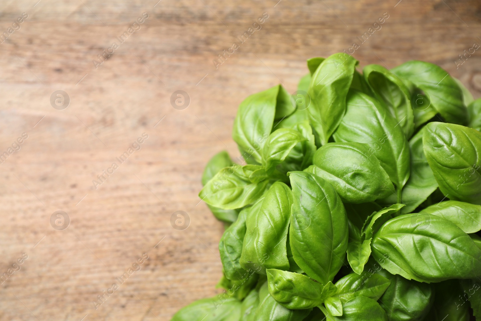Fresh basil on wooden table, top view. Space for text Photo of Fresh basil on wooden table, top view. Space for text