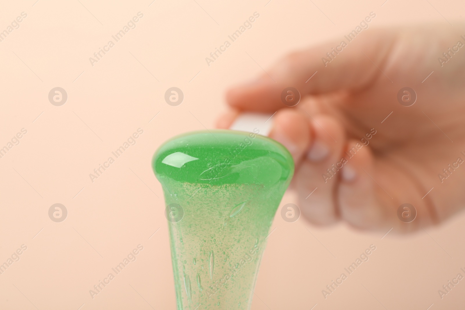 Woman holding spatula with hot depilatory wax on beige background, closeup Photo of Woman holding spatula with hot depilatory wax on beige background, closeup
