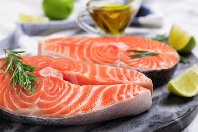 Fresh raw salmon with rosemary and lime on stone board. Fish delicacy Photo of Fresh raw salmon with rosemary and lime on stone board. Fish delicacy